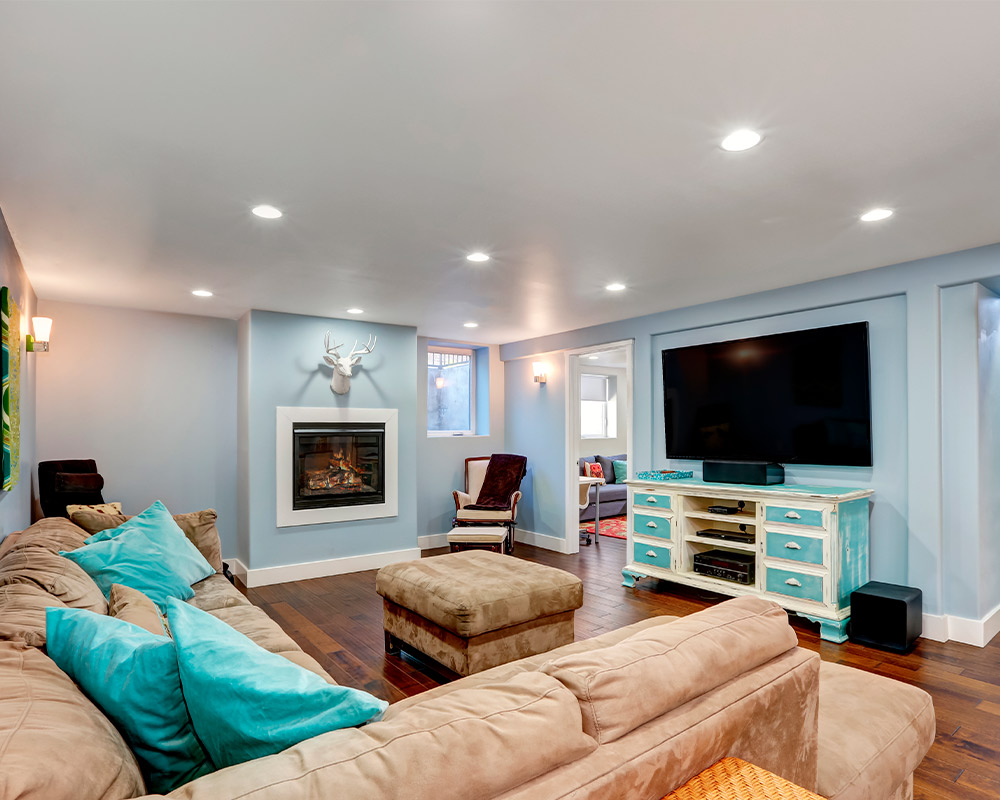A modern living room with a blue wall and a fireplace, emphasizing the benefits of remodeling your basement space.