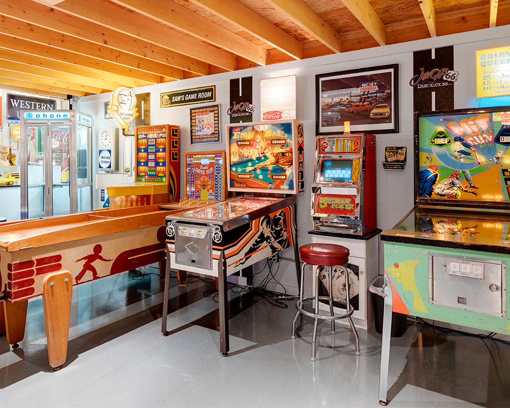 A lively basement room filled with pinball machines and arcade games, highlighting a unique recreational area.