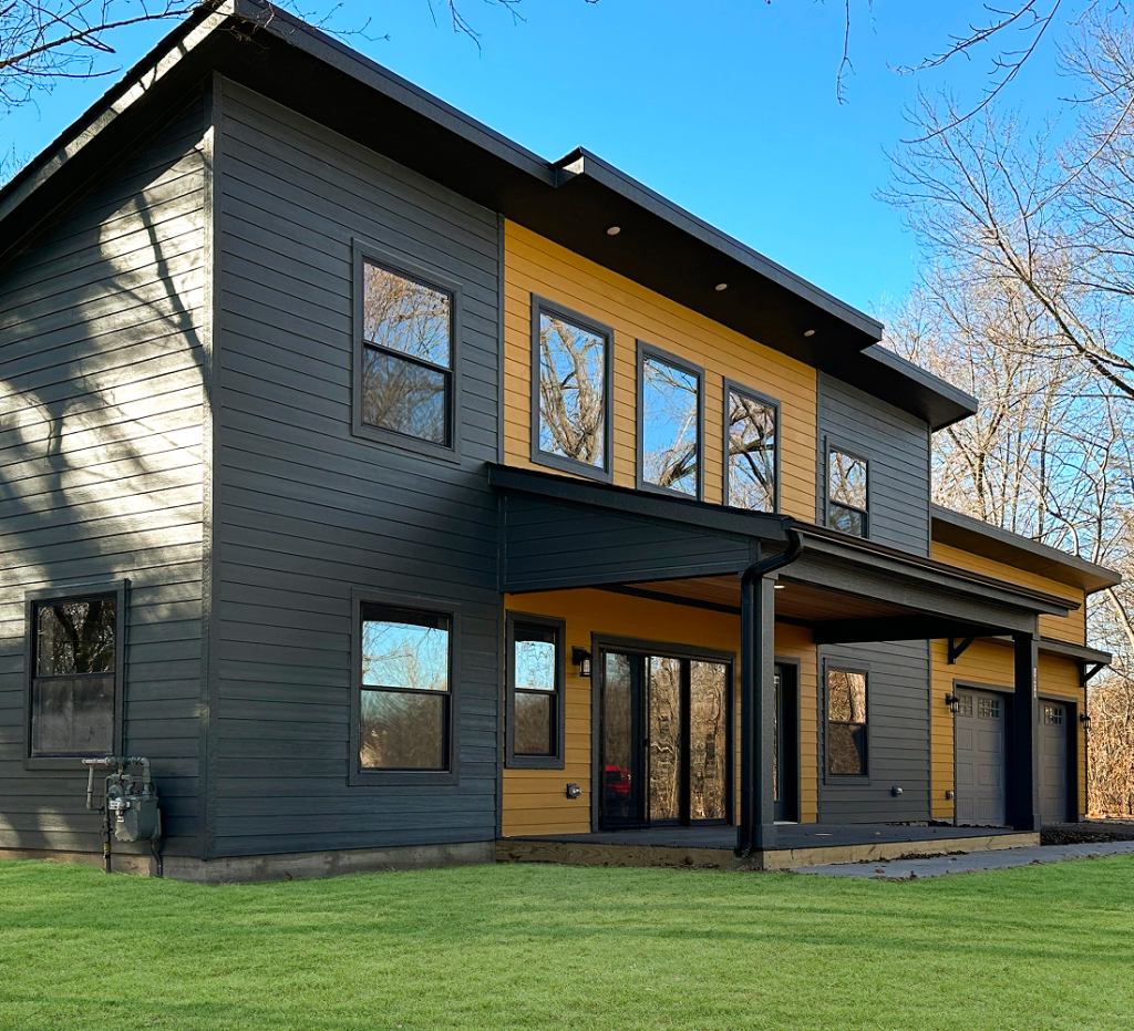 modern, two-story house exterior with dark grey and golden yellow siding