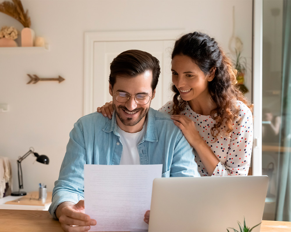 Man and woman examining documents at home, planning their custom home project with builders in Barrington.