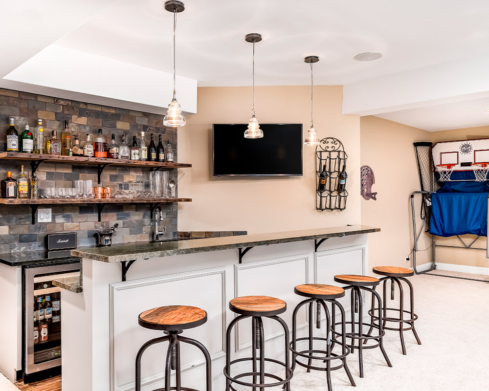  A stylish home bar with stools and a refrigerator, designed for a basement remodeling project in Naperville homes.