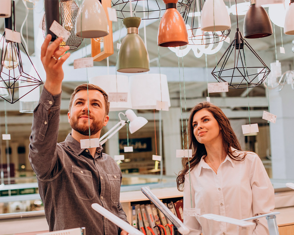 A couple inspects ceiling lights, contemplating design choices for a basement remodel project in Hinsdale.