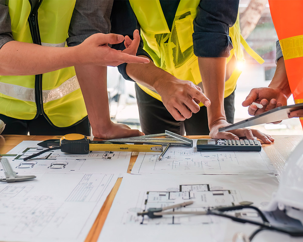  Three workers in safety vests engaged in a construction project for custom home building.