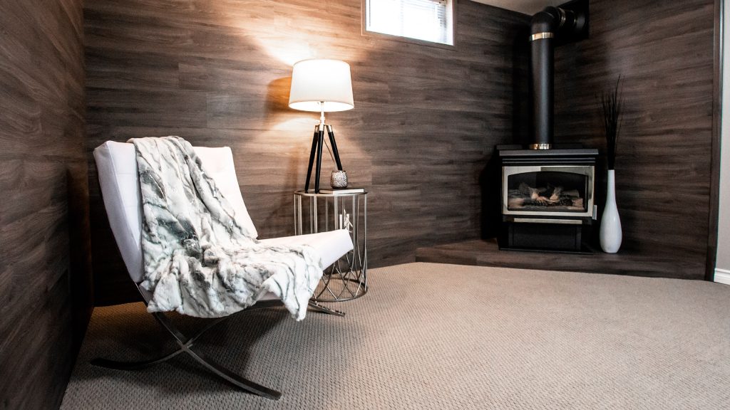 A small, inviting room with a fireplace and a chair, perfect for winter-proofing your basement in Chicagoland.